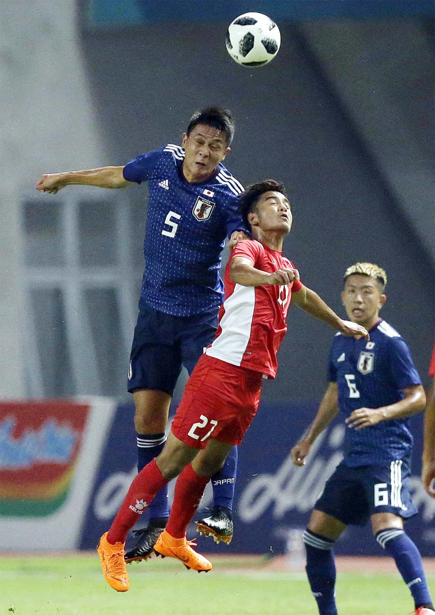 Japan's Daiki Sugioka (left) battles for the ball with Nepal's Abishek Rijal during their men's soccer match at the 18th Asian Games at Wibawa Mukti Stadium in Cikarang, Indonesia on Tuesday.