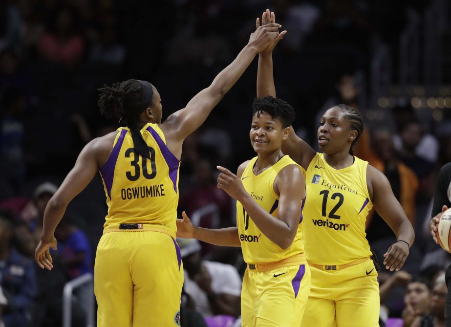 Los Angeles Sparks' Chelsea Gray (12) celebrates her basket with teammates Nneka Ogwumike (30) and Alana Beard during the second half of a WNBA basketball game against the New York Liberty in Los Angeles on Tuesday.