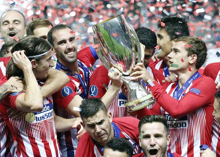 Atletico Madrid teammates celebrate and lift the trophy after winning the UEFA Super Cup final soccer match between Real Madrid and Atletico Madrid at the Lillekula stadium in Tallinn, Estonia on Wednesday.