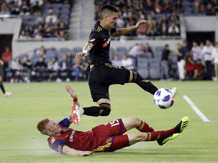 Los Angeles FC midfielder Eduard Atuesta (top) leaps over Real Salt Lake defender Justen Glad during the second half of an MLS soccer match in Los Angeles on Wednesday.