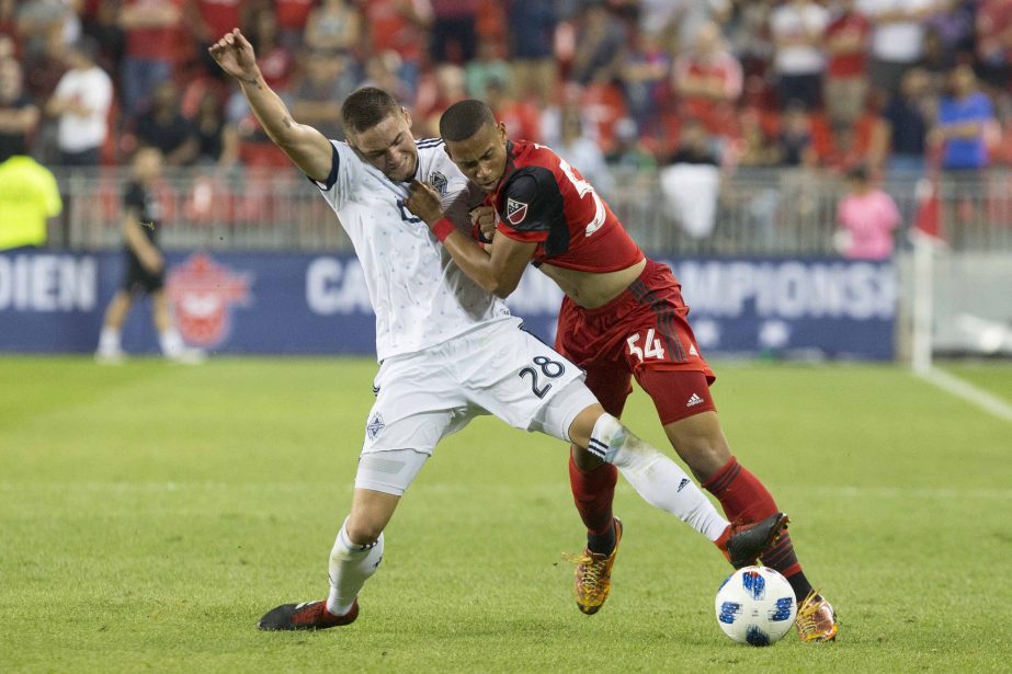 Toronto FC forward Ryan Telfer (right) battles for the ball with Vancouver Whitecaps' Jake Nerwinski during the second half in the second leg of the Canadian soccer championship final in Toronto on Wednesday.