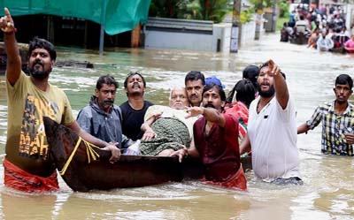 People move past a flooded area in Thrissur, in the southern Indian state of Kerala, on Friday.