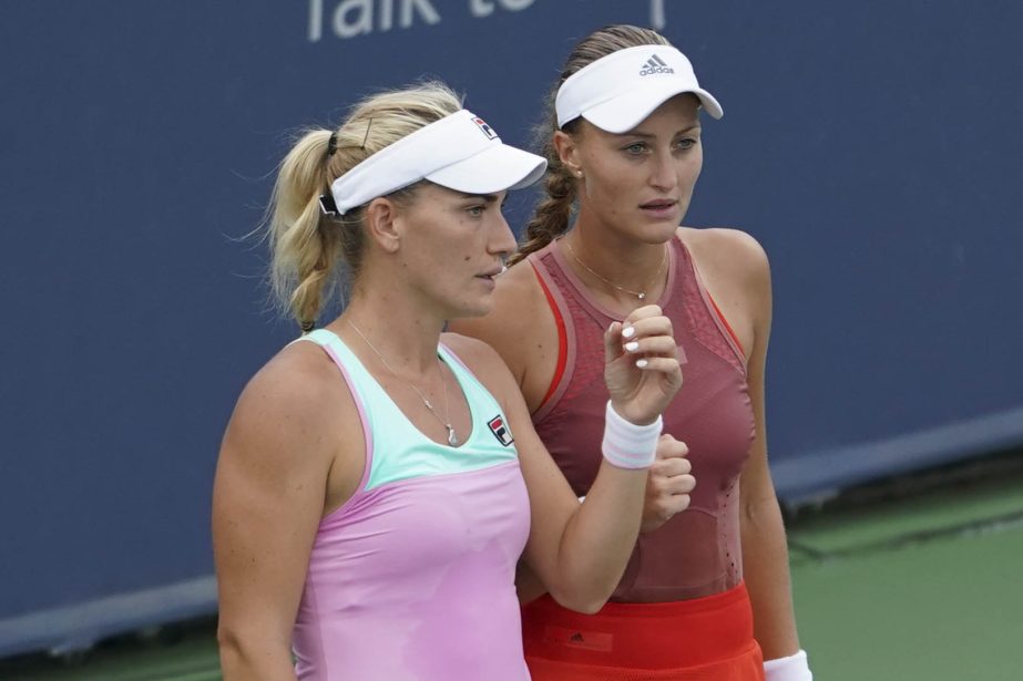 Timea Babos (left) of Hungary, prepares with her partner Kristina Mladenovic (right) of France, during a doubles match against Ekaterina Makarova, of Russia, and Lucie Hradecka, of the Czech Republic, at the Western & Southern Open tennis tournament on Fr