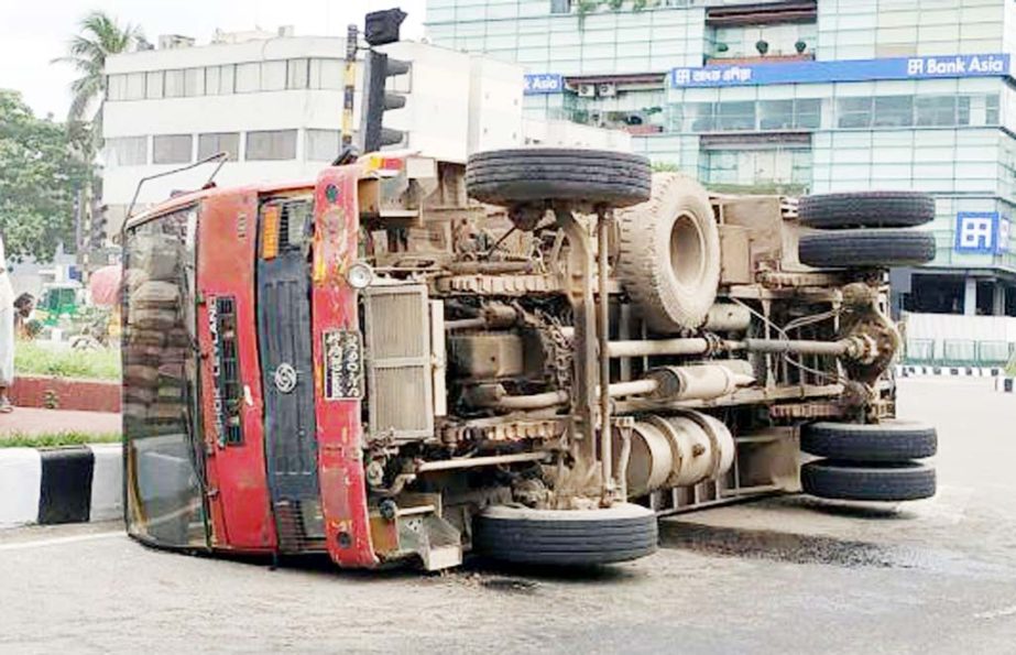 A covered van turned over for driving recklessly in the city's Bijoy Swarani intersection. The snap was taken from the spot on Friday.