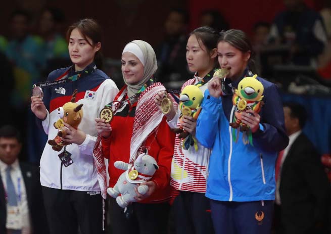 From left, silver medalist Jandi Kim of Korea, gold medalist Julyana al sadeq of Jordan, bronze medalist Mengyu Zhang of China and bronze medalist Nigora Tursunkulova of Uzbekistan during ceremonies their women's featherweight 67-kilogram Taekwondo match