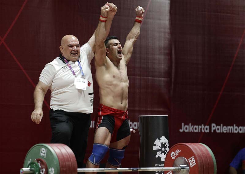 Iraq's Safaa Aljumaili, right, celebrates with a member of his team after winning gold during the men's 85kg weightlifting at the 18th Asian Games in Jakarta, Indonesia on Friday.