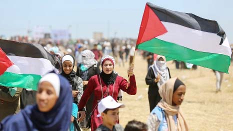 Palestinian protesters wave flags during clashes after protests near the border with Israel on the eastern Gaza Strip