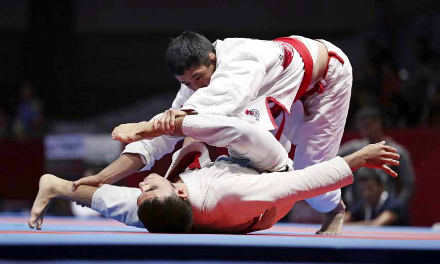 Omar Alfadhli of United Arab Emirates (bottom) competes against Alymgeldi Abdizhamil Uulu of Kyrgyzstan (top) during Newaza Men's -62kg 14 Ju-jitsu finals at the 18th Asian Games in Jakarta, Indonesia on Saturday.