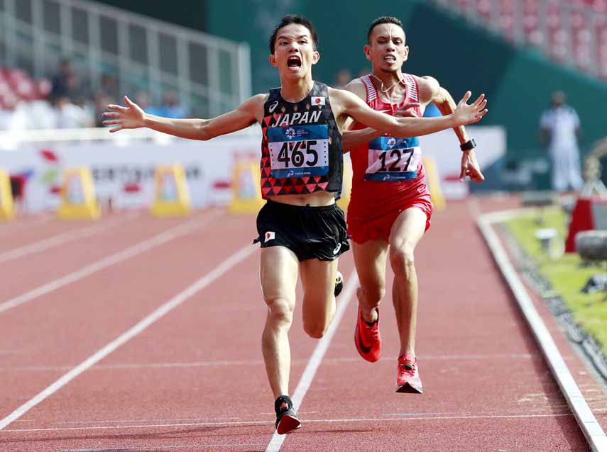 Japan's Hiroto Inoue (left) crosses the finish line ahead of Bahrain's Elhassan Elabbassi to win the men's marathon at the 18th Asian Games in Jakarta, Indonesia on Saturday.