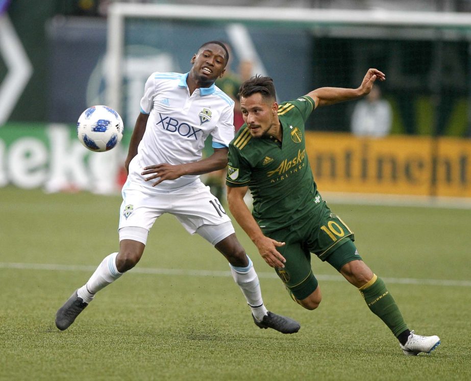 Portland Timbers' Sebastian Blanco (10) fights for the ball against Seattle Sounders' Kelvin Leerdam during an MLS soccer match in Portland on Sunday.