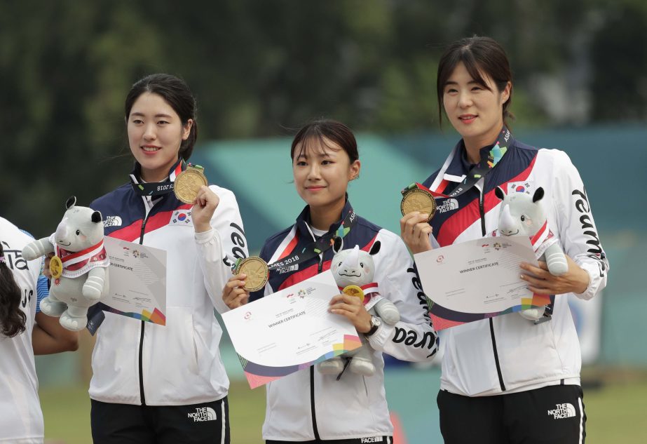 Gold medalists South Korea's Choi Bo-min, So Chae-won and Song Yun-soo celebrate during the victory ceremony for the archery compound women's team match at the 18th Asian Games in Jakarta, Indonesia on Tuesday.