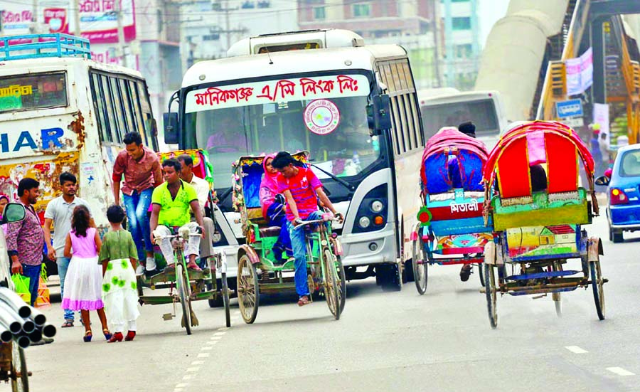 Though light transports like electric rickshaws and vans are banned to ply on the Highways but who cares as heavy vehicles being obstructed to run slowly due to disruption by light vehicles. This photo was taken from Hemayetpur area on Tuesday. (Inset) Dr