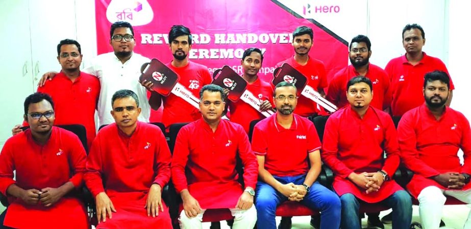 Muhammad Mehedi Hasan, Cluster Market Director of Robi, poses for a photograph with the key handing over ceremony of Duronto quarter long campaign winners among its sales representatives at its head office in the city recently. Top officials of the compan