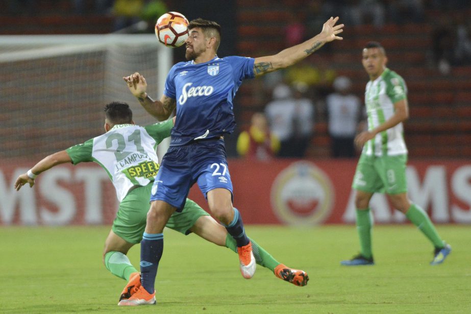 Leandro Diaz of Argentina's Atletico Tucuman goes for a header as Jorman Campuano of Colombia's Atletico Nacional (left) falls during a Copa Libertadores round of sixteen soccer match in Medellin, Colombia on Tuesday.