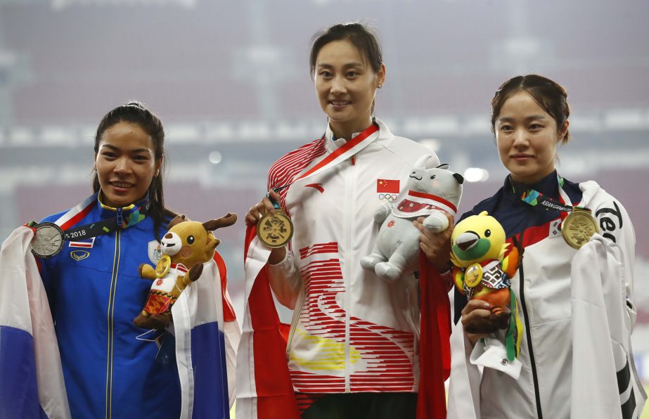Women's pole vault gold medalist China's Li Ling (centre) stands with silver medalist, Thailand's Chayanisa Chomchuendee left, and bronze medalist South Korea's Lim Eunji on the podium during the athletics competition at the 18th Asian Games in Jakart