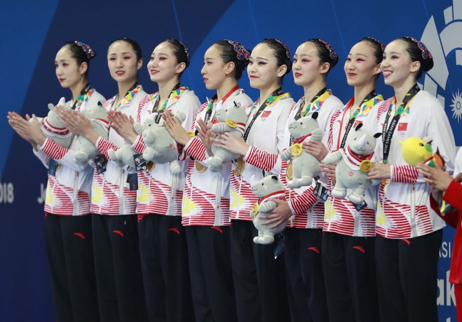 Team China celebrate on the podium after winning the gold medal at the synchronized swimming competition at the 18th Asian Games at Gelora Bung Karno Aquatics Center in Jakarta, Indonesia on Wednesday.