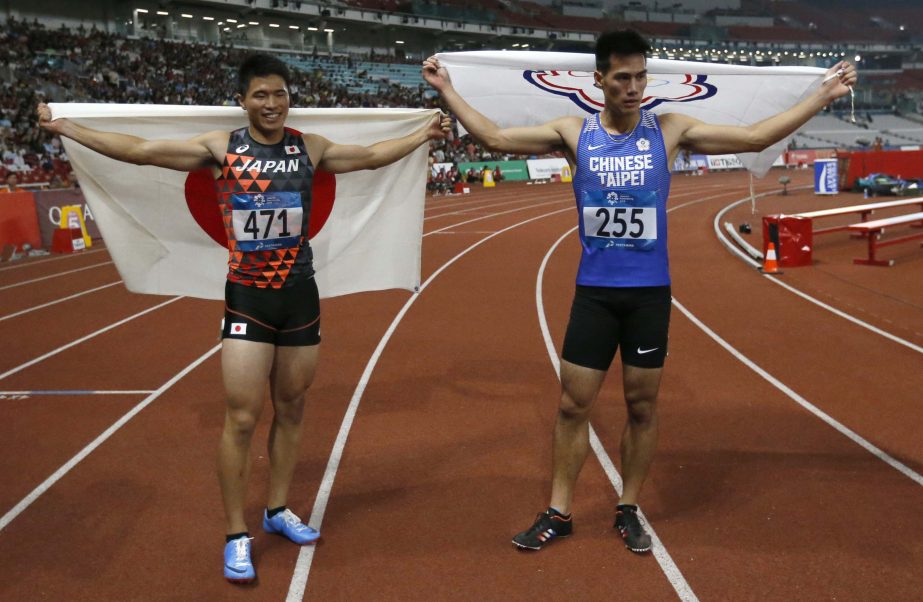 Japan's Yuki Koike (left) stands by second placed Taiwan's Yang Chunhan after winning the men's 200m final during the athletics competition at the 18th Asian Games in Jakarta, Indonesia on Wednesday.