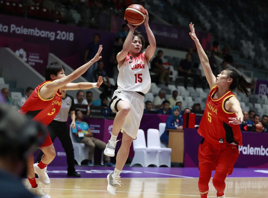 Japan's Shiori Yasuma (center) drives past China's Yang Liwei (left) and China's Wang Siyu during their women's basketball semifinal match at the 18th Asian Games at Istora Stadium in Jakarta, Indonesia on Thursday.