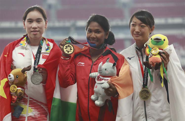 Heptathlon gold medalist India's Swapna Barman (center) stands with silver medalist China's Wang Qingling (left) and bronze medalist Japan's Yuki Yamasaki on the podium during the athletics competition at the 18th Asian Games in Jakarta, Indonesia on T