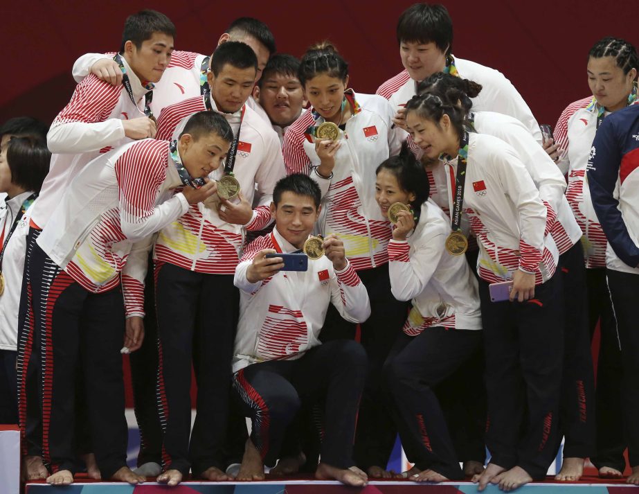 China team pose for a selfie with bronze medals during the victory ceremonies mixed team judo at the 18th Asian Games in Jakarta, Indonesia on Saturday.