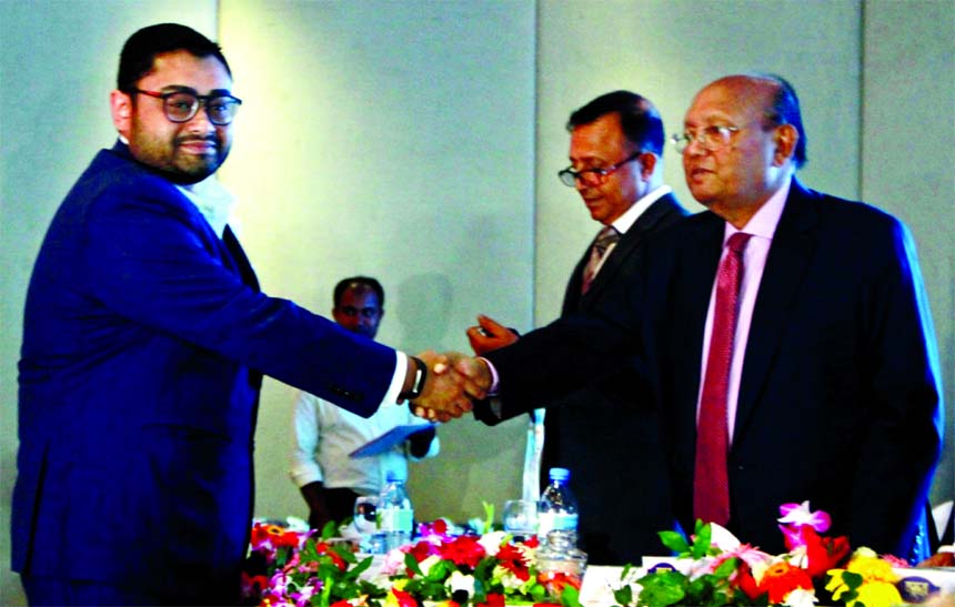 Commerce Minister Tofail Ahmed, handing over a CIP card (Export Trade)-2015 to Tanvir Ahmed, Director of Envoy and Sheltech Group at a hotel in the city on Monday.