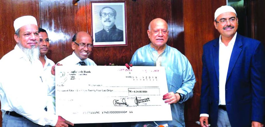 Finance Minister AMA Muhith receiving a cheque of Tk 6.24 crore as dividend from Grameen Bankâ€™s acting Managing Director Babul Saha at a ceremony held at the Bangladesh Secretariat on Thursday. The Bank provides the amount to the government against