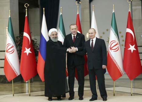 Iran's President Hassan Rouhani, left, Russia's President Vladimir Putin, right, and Turkey's President Recep Tayyip Erdogan lock hands during a group photo in Ankara, Turkey.