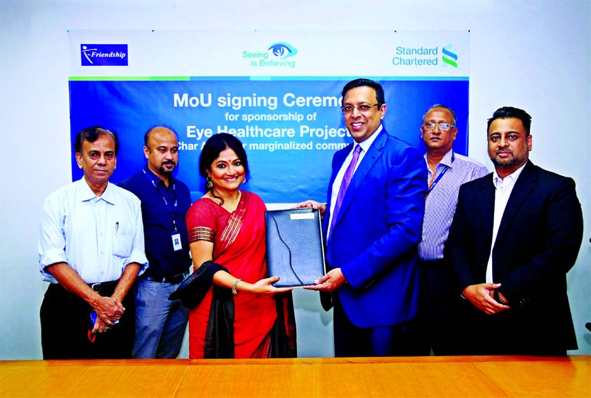 Naser Ezaz Bijoy, CEO of Standard Chartered Bank and Runa Khan, founder and Executive Director of Friendship (an NGO), exchanging a MoU signing document to tackle avoidable blindness in hard-to-reach, marginalized char (River Island) communities in northe