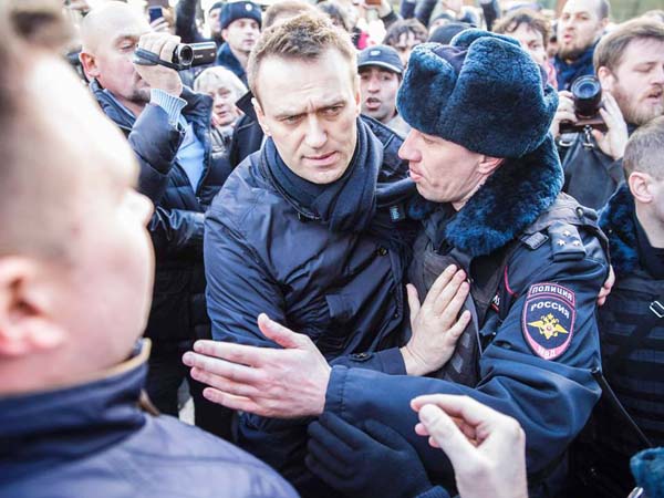 Police officers detaining Kremlin critic Alexei Navalny during an unauthorised anti-corruption rally in central Moscow.