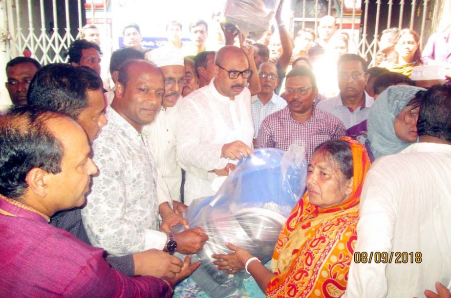 CCC Mayor A J M Nasir Uddin distributing relief materials among the fire victims at Askardighi par on Saturday.