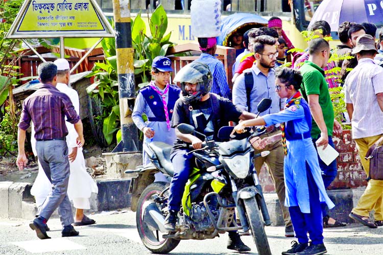 Members of Girl Guides cooperating traffic police just to create awareness among the pedestrians about the traffic discipline for road safety. This photo was taken from Shahbagh area on Sunday.