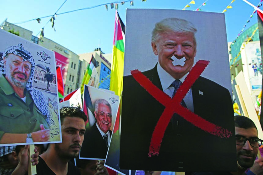 Palestinian protestors hold portraits of late Palestinian leader Yasser Arafat and US President Donald Trump during a rally in support to the Fatah movement in the West Bank city of Nablus.