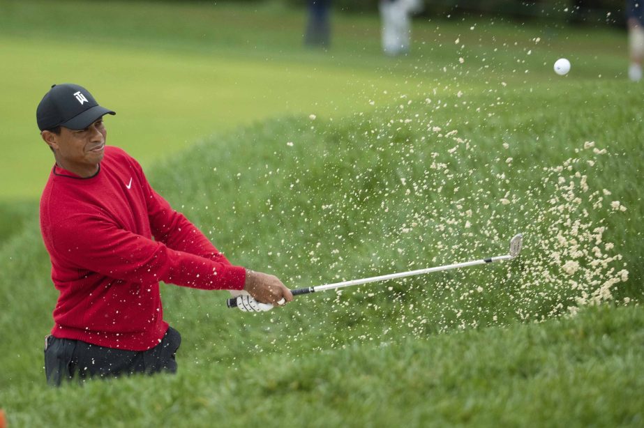 Tiger Woods hits the ball out of the bunker on the 14th hole during the BMW Championship golf tournament at the Aronimink Golf Club on Monday in Newtown Square, Pa.