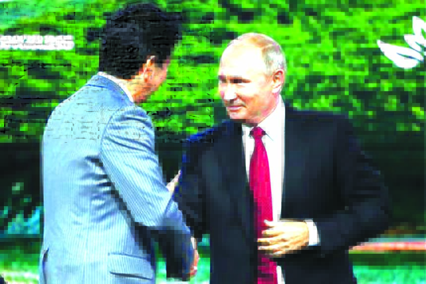 Japanese Prime Minister Shinzo Abe (L) shakes hands with Russian President Vladimir Putin during a session of the Eastern Economic Forum in Vladivostok, Russia on Wednesday.