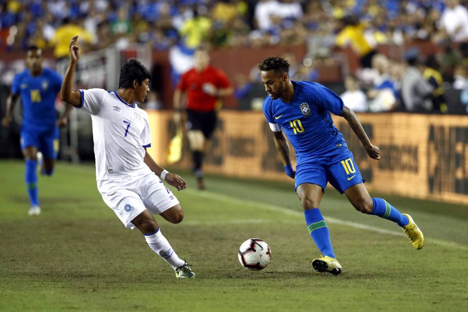 Brazil forward Neymar (right) dribbles the ball around El Salvador midfielder Gilberto Baires in the first half of a soccer match in Landover, Md. on Tuesday.