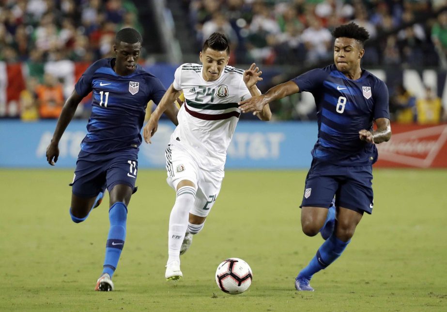 Mexico midfielder Roberto Alvarado (24) dribbles the ball past US midfielders Tim Weah (11) and Weston McKennie (8) during an international friendly match in Nashville, Tenn on Tuesday.