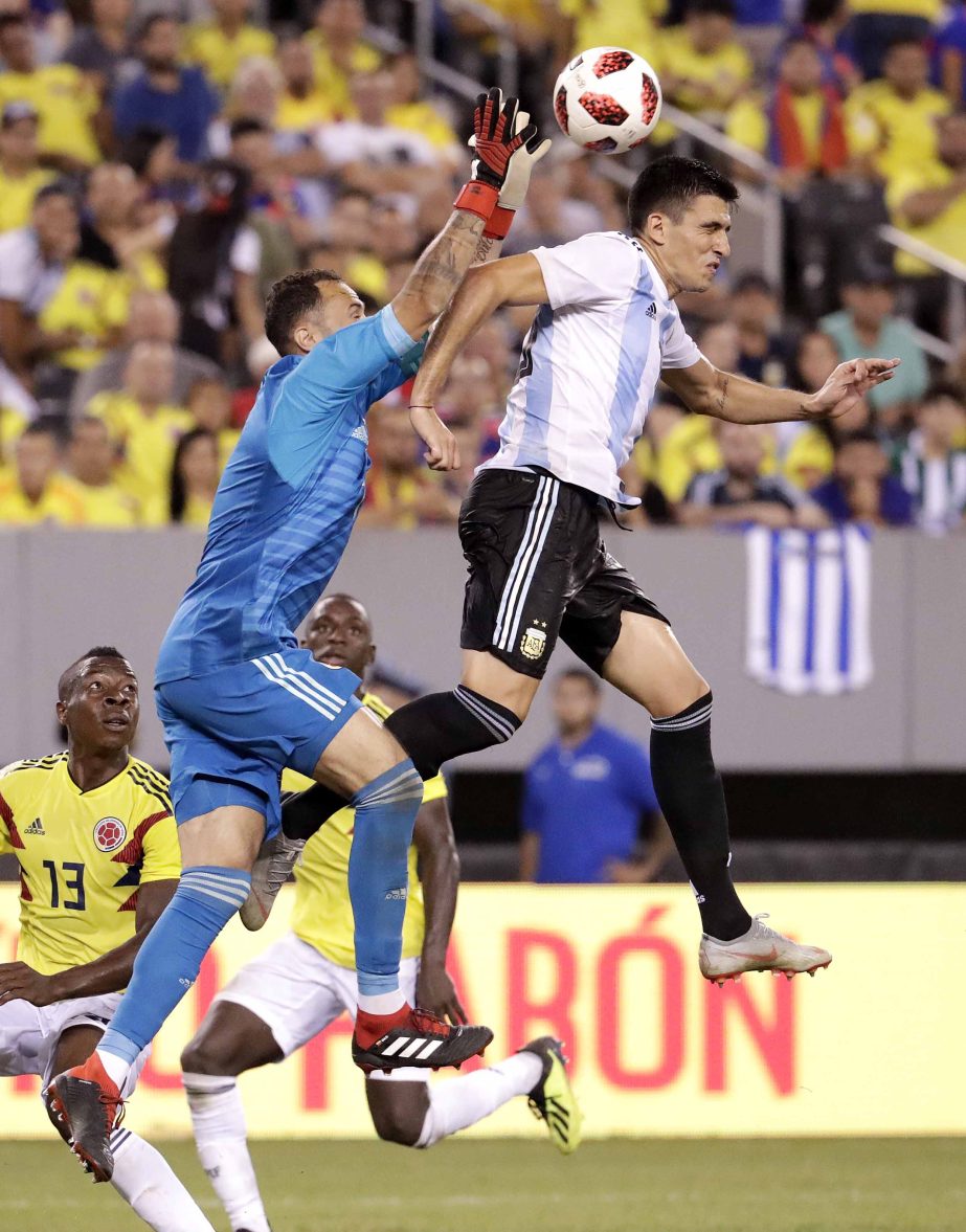 Colombia goalkeeper David Ospina (left) reaches to make a save as Argentina's Rodrigo Battaglia challenges for the ball during the second half of a international soccer friendly match in East Rutherford, N.J. on Tuesday.