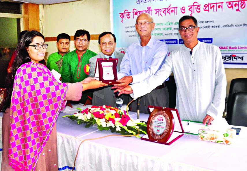 Education Minister Nurul Islam Nahid distributing scholarships among the students who made good results in the SSC and HSC examinations-2018 at a reception organised by Dhaka Reporters Unity in its auditorium on Friday.