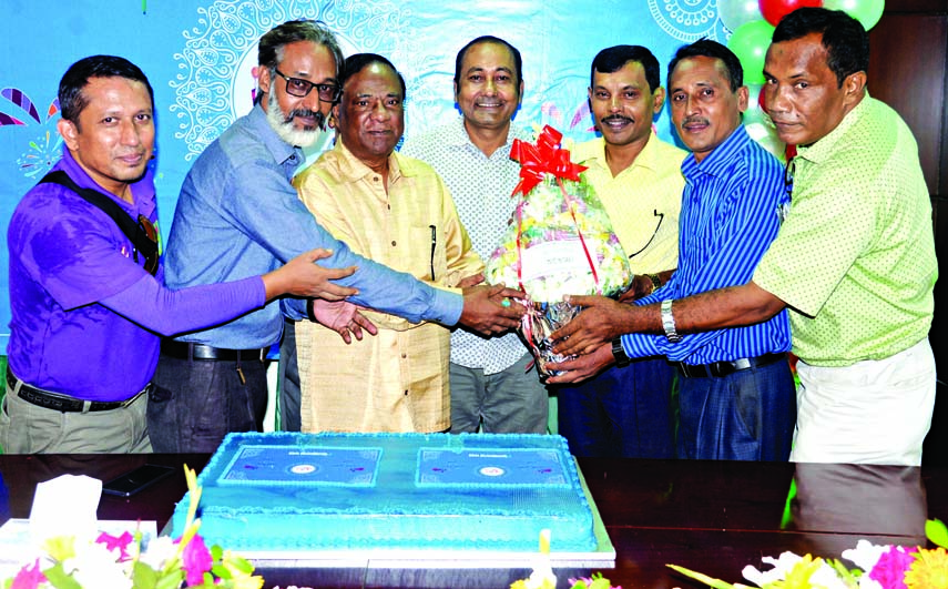 Members of Bangladesh Photojournalists Association greet the Editor of the Dainik Bangladesher Khabar Azizul Islam Bhuiyan by presenting bouquet at its office in the city on Saturday.