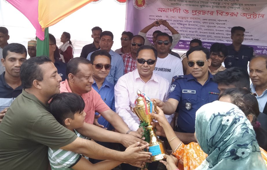DC of Patuakhali District Dr Masumur Rahman handing over the trophy to Patuakhali Sadar Upazila Football team, which emerged as the champions of the district level of the Bangabandhu Sheikh Mujibur Rahman National Gold Cup Football (Under-17) Tournament a