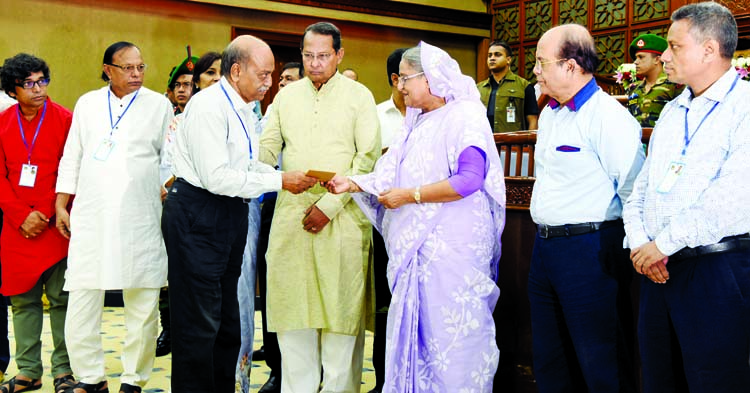 Prime Minister Sheikh Hasina distributing assistance among the needy journalists from Bangladesh Journalists' Welfare Trust Fund at a function held at her office on Wednesday. PID photo