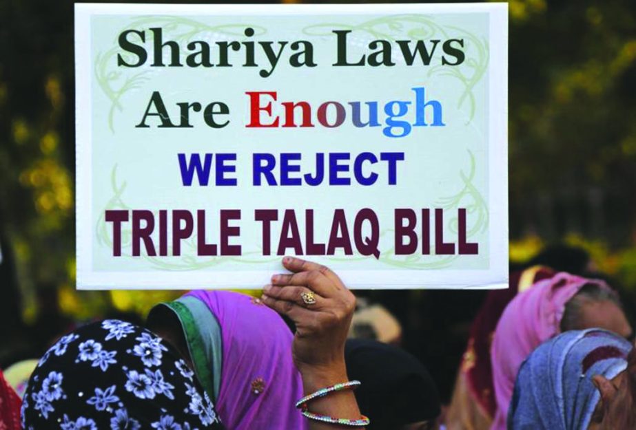 An Indian Muslim woman holds a placard during a protest against a new draft law aimed at banning "Triple Talaq," a Muslim practice of instant divorce in Ahmadabad, India. India's government on Wednesday approved an ordinance to implement a top court ru