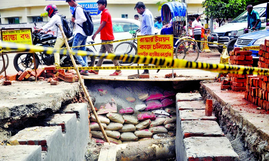 Vehicles moving on iron sheets spread over under construction road in the wake of slow pace of development work at Rajarbagh area on Thursday amid fears of accident anytime.