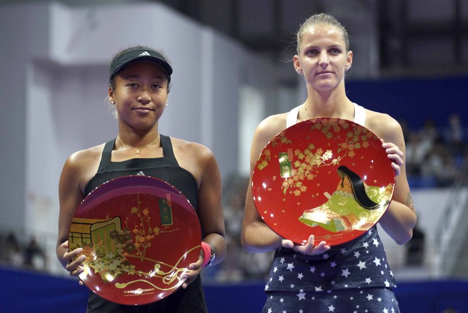 Karolina Pliskova (right) of Czech Republic, holds her champion trophy and Naomi Osaka (left) of Japan holds her runner-up trophy during the award ceremony of the Pan Pacific Open women's tennis tournament in Tokyo on Sunday.