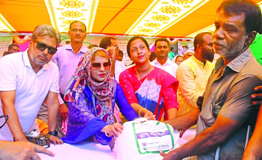 Zainul Haque Sikder, Chairman of Sikder Group and National Bank Limited along with Sanjida Yeasmin, UNO of Naria Upazila of Shariatpur district distributing relief items among the river erosion affected people at the Upazila recently. Parveen Haque Sikder