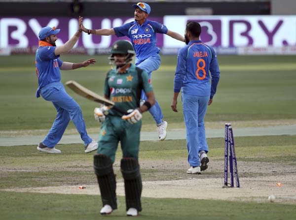 India's captain Rohit Sharma (left) celebrates with teammates the dismissal of Pakistan's Babar Azam (front) during the one day international cricket match of Asia Cup between India and Pakistan in Dubai, United Arab Emirates on Sunday.