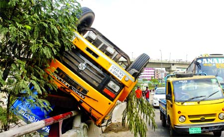 A covered van overturned due to reckless driving near Kuril Flyover on Monday injuring the driver and his helper.