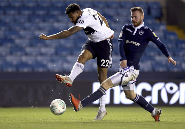 Fulham's Cyrus Christie (left) attempts a shot at goal against Millwall during the third round English League Cup soccer match at The New Den in London on Tuesday.