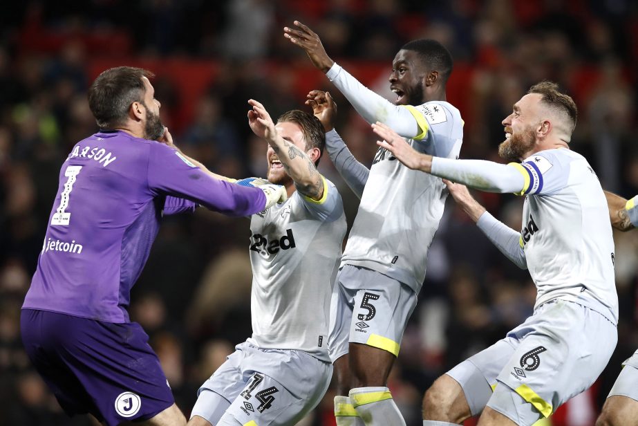 Derby County goalkeeper Scott Carson (left) celebrates winning the penalty shootout with teammates against Manchester United during the English League Cup, third round soccer match at Old Trafford in Manchester, England on Tuesday.