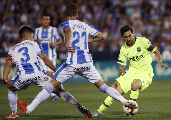 FC Barcelona's Lionel Messi (right) duels for the ball during the Spanish La Liga soccer match between Leganes and FC Barcelona at the Butarque stadium in Leganes, Spain on Wednesday.